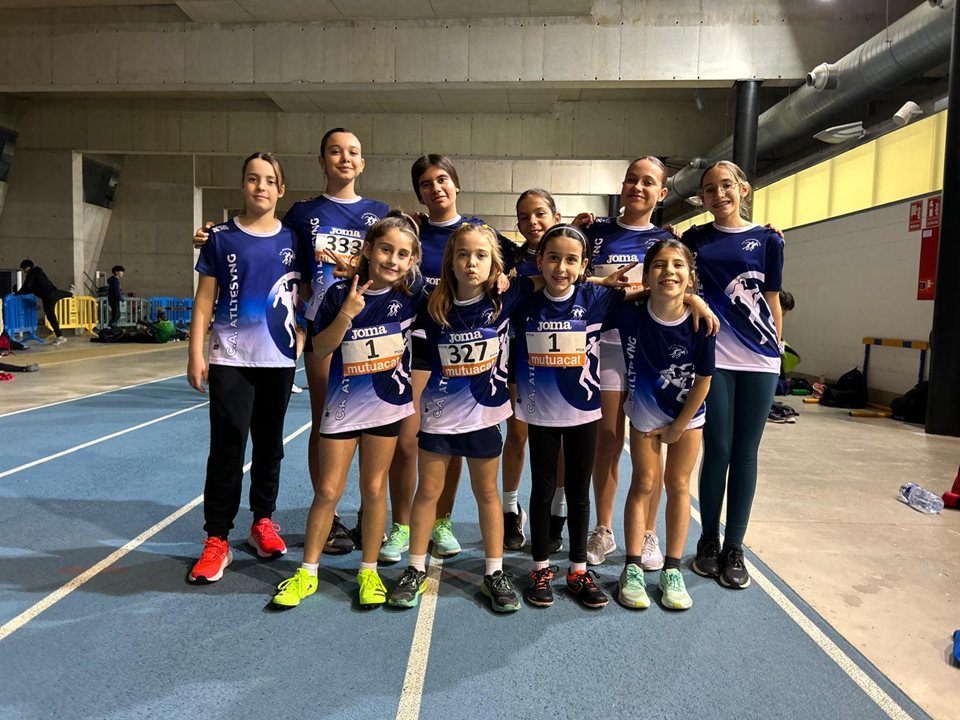 Grup de joves en una pista d’atletisme coberta.