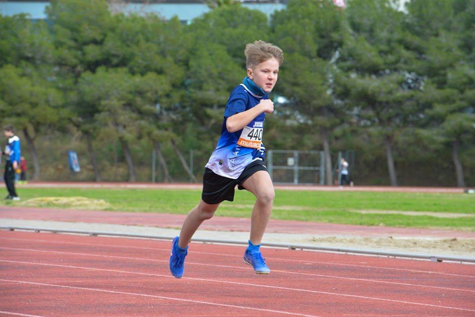 Atleta jove corrent per la pista.